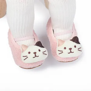 Detail showing cute cartoon cat face on pink plush baby walking shoes for infants