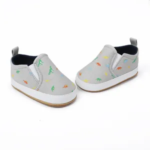 Grey baby slip-on canvas shoes featuring colorful dinosaur prints and a white rubber sole