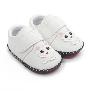 Detailansicht der weißen Baby-Lauflernschuhe mit Cartoon-Katze und Handnaht-Sohle