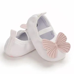 Detail shot of white baby walker shoes featuring a delicate pink butterfly applique.