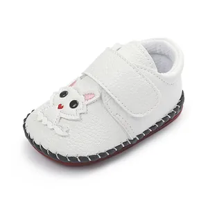 Detailansicht der weißen Baby-Lauflernschuhe mit süßem Cartoon-Motiv und Handnaht