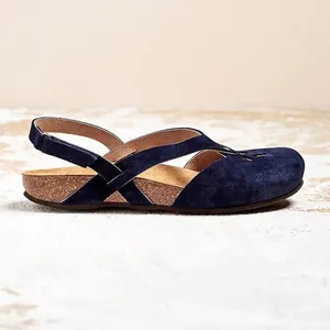 Side view of navy blue round toe hollow-out flat sandals with soft suede texture and cork sole