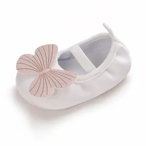 Detailed view of white infant girl walking shoe featuring a soft pink butterfly bow