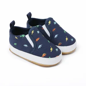 Detailweergave van marineblauwe baby instapschoenen met kleurrijke dinosaurusprint