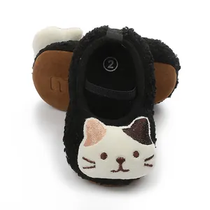 Close-up detail of fuzzy black baby walking shoes featuring a cute embroidered white cat face