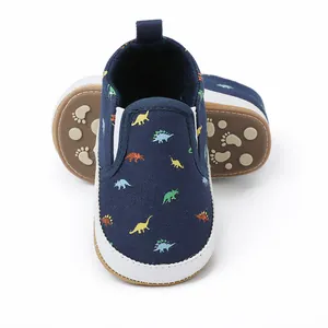 Detailopname van marineblauwe baby canvas schoenen met dinosaurusprint en antislipzool