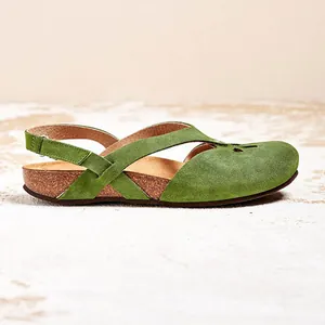 Close-up side view of green suede hollow-out flat sandals for women.