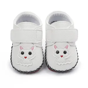 Detailansicht weißer Babylaufschuhe mit niedlichem Katzen-Patch und Klettverschluss
