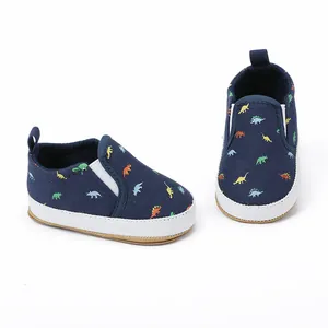 Detail view of navy blue canvas baby shoes with colorful dinosaur patterns