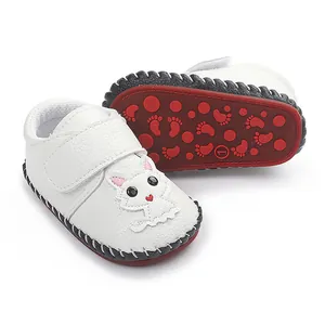 Detailansicht der weißen Baby-Lernlaufschuhe mit Cartoon-Katzen-Patch und roter Antirutschsohle