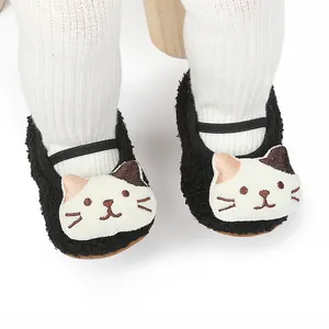 Close-up of black fleece baby walking shoes featuring a cute cartoon cat face design