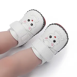 Nahaufnahme weißer handgenähter Babyschuhe mit süßer Cartoon-Katzenstickerei
