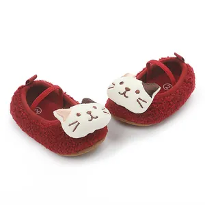 Close-up detail of red fleece baby pre-walker shoes featuring a cute cartoon cat face