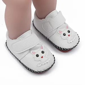 Nahaufnahme der weißen Baby-Lernlaufschuhe mit Katzenmotiv und rutschfester Gummisohle.