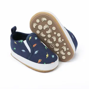 Detailweergave van marineblauwe baby canvas schoenen met kleurrijke dinosaurusprint