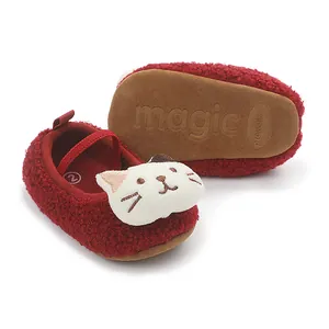 Close-up detail of red sherpa baby shoes featuring a 3D cartoon cat head design.