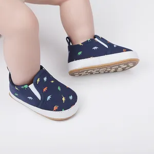 Close-up van donkerblauwe baby instapschoenen met kleurrijke dinosaurusprints voor peuters