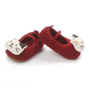 Macro view of red fuzzy infant shoes featuring cute cartoon cat faces with soft soles