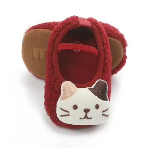 Detail of cozy red sherpa infant pre-walker shoes with cute cartoon cat embroidery.
