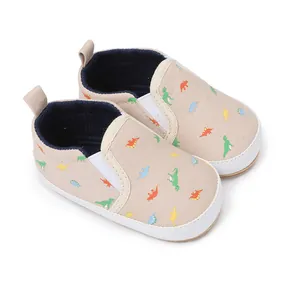 Gedetailleerd overzicht van instapschoenen voor baby's met dinosaurusprint op beige canvas