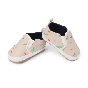 Detailed macro view of infant slip-on pre-walker shoes featuring a dinosaur pattern