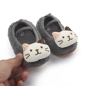 Close-up of soft gray fuzzy baby shoes featuring a cute 3D cartoon cat face detail