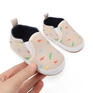 Detailweergave van baby instapschoenen met kleurrijk dinosauruspatroon en zachte zool.