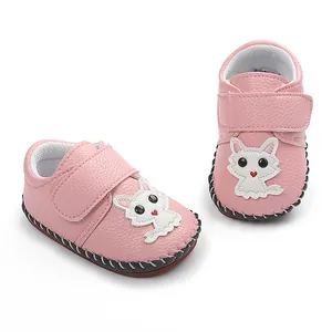 Nahaufnahme rosa rutschfeste Babyschuhe mit weißer Zeichentrickkatze und handgenähter Sohle
