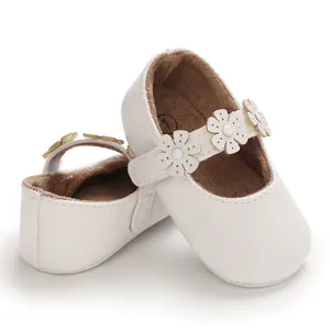 Detailansicht weißer Babylauflernschuhe mit zarten Blumenapplikationen auf den Riemen.