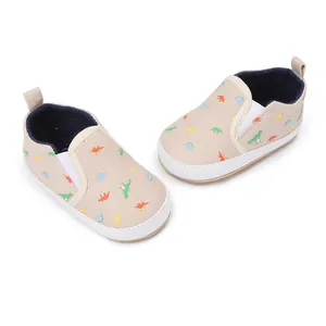 Beige canvas baby slip-on shoes with colorful dinosaur print for infants and toddlers