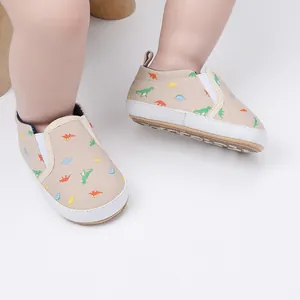 Detail van babyschoentjes met dinosaurusprint en zachte rubberen zool voor peuters.