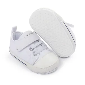 Chaussures en toile blanches pour bébé avec semelle en caoutchouc antidérapante.