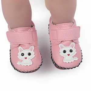 Nahaufnahme von rosa Baby-Lauflernschuhen mit süßem weißem Zeichentrick-Katzen-Design