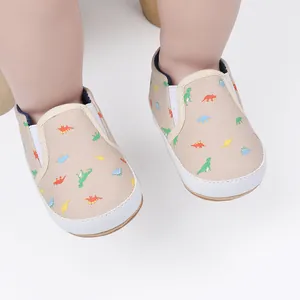 Detail van baby canvas instapschoenen met kleurrijke dinosaurusprint en witte zolen