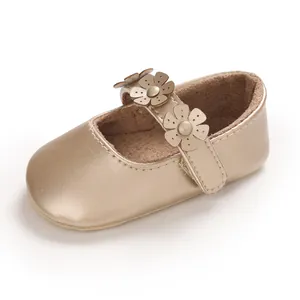 Nahaufnahme goldener Babylauflernschuh mit Blumenriemen und weicher Sohlendetails.