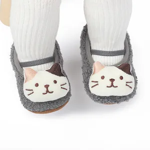 Close-up of grey plush baby walking shoes featuring a cute cartoon cat face design.