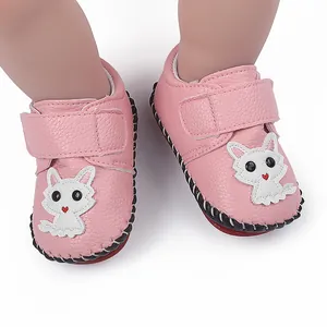 Detailansicht rosa Babyschuhe mit weißem Cartoon-Katzenaufnäher und rutschfester Sohle