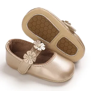Detailansicht goldener Lauflernschuhe für Babys mit Blumendesign und rutschfester Sohle.