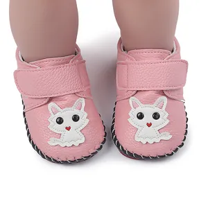 Nahaufnahme rosa Babyschuhe mit süßem weißem Katzen-Patch und handgenähten Sohlen