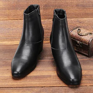 Detailansicht der schwarzen Herren-Chelsea-Stiefeletten mit Absatz auf Holzgrund