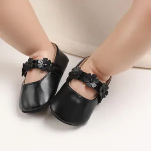 Detailansicht schwarzer Baby-Lauflernschuhe mit dekorativen Blumen am Riemen für Mädchen.