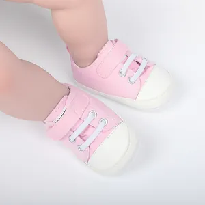 Gros plan de chaussures de marche en toile rose pour bébé avec semelles en caoutchouc