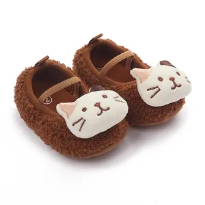 Detail of brown plush baby shoes with 3D cat face embroidery and soft elastic strap