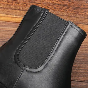 Nahaufnahme der elastischen Seite und Nähte eines schwarzen Chelsea-Boots aus Leder.