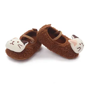 Close-up of brown fluffy baby walking shoes with cute white cartoon cat faces