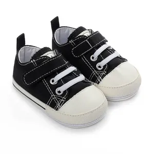 Baskets en toile classiques noir et blanc pour bébés avec semelles en caoutchouc souple.