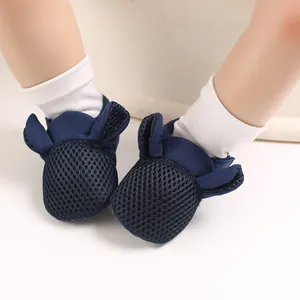 Dettaglio delle scarpine primi passi per neonati in mesh blu con orecchie da coniglio