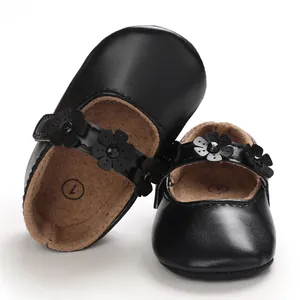 Detaillierte Ansicht der schwarzen Baby-Mary-Janes mit einem dekorativen Blumenriemen
