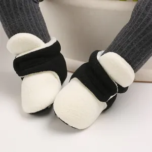 Macro view showing the soft fleece texture of black and white baby winter shoes