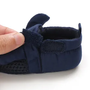 Dettaglio scarpa neonato blu navy con chiusura in velcro regolabile